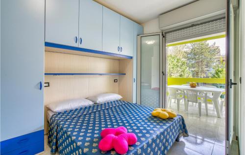 una camera da letto con un letto con sopra degli animali rosa ripieni di Beautiful Apartment In Bibione With 1 Bedrooms, Wifi And Outdoor Swimming Pool a Bibione