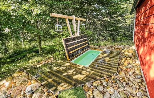 a bench with a swimming pool in a backyard at Gorgeous Home In Laholm With Kitchen in Laholm