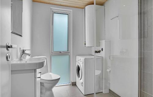 uma casa de banho branca com uma máquina de lavar e secar roupa em Beautiful Home In Lkken With Wifi em Grønhøj