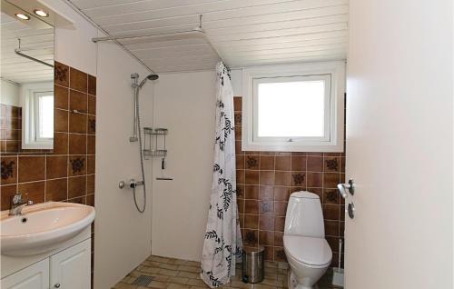 a bathroom with a toilet and a sink and a window at El-bo in Snogebæk