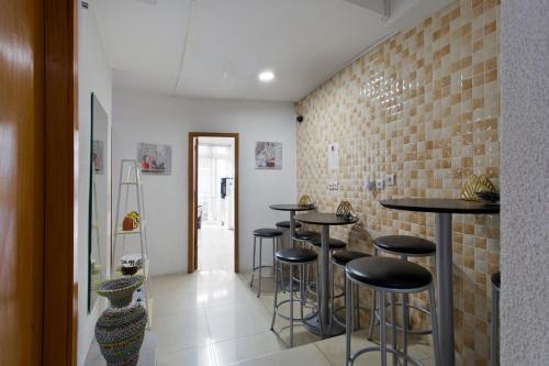 a bar with black stools and a brick wall at Braganca Oporto in Porto