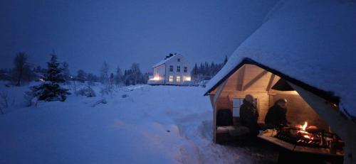 a couple of people standing outside of a tent in the snow at Villa Fregn in Ljørdal