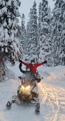 two people riding on a snowmobile in the snow at Villa Fregn in Ljørdal