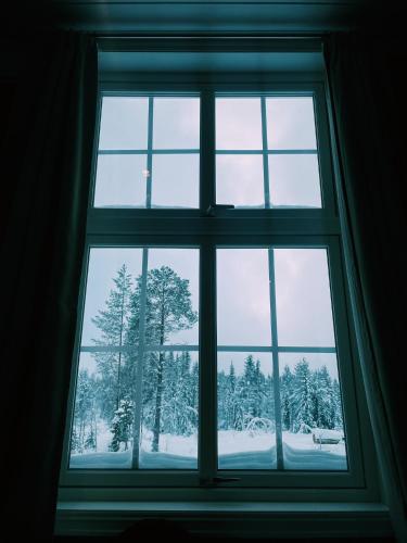 a window looking out at a snow covered forest at Villa Fregn in Ljørdal