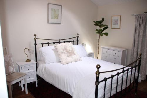 Un dormitorio con una cama con sábanas blancas y una planta en Gites79 - Gite des Chirons, 30mins from Puy du Fou, en La Forêt-sur-Sèvre