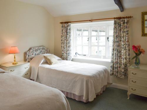 a bedroom with two beds and a window at Lilac Cottage in Sinnington