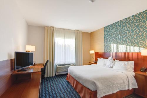 ナッキトッシュにあるFairfield Inn and Suites by Marriott Natchitochesのベッド1台、薄型テレビが備わるホテルルームです。