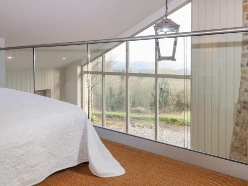 1 dormitorio con cama y ventana grande en Beckaford View, en Newton Abbot