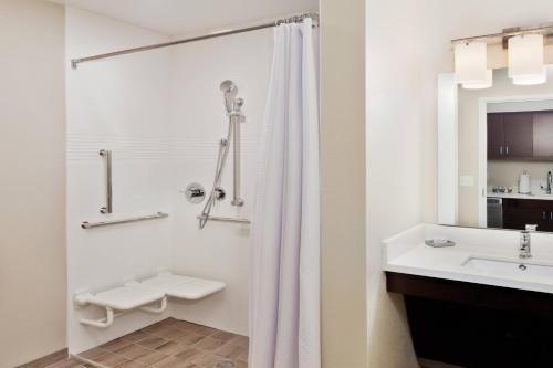 ein weißes Bad mit einer Dusche und einem Waschbecken in der Unterkunft TownePlace Suites by Marriott Montgomery EastChase in Montgomery