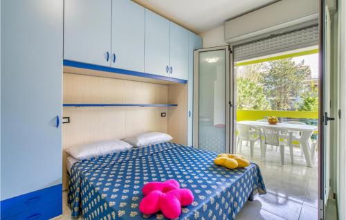 Schlafzimmer mit einem Bett mit rosa ausgestopften Tieren in der Unterkunft Beautiful Apartment In Bibione With Outdoor Swimming Pool in Bibione