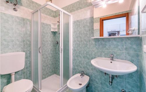 ein Bad mit einem Waschbecken, einem WC und einer Dusche in der Unterkunft Beautiful Apartment In Bibione With Outdoor Swimming Pool in Bibione
