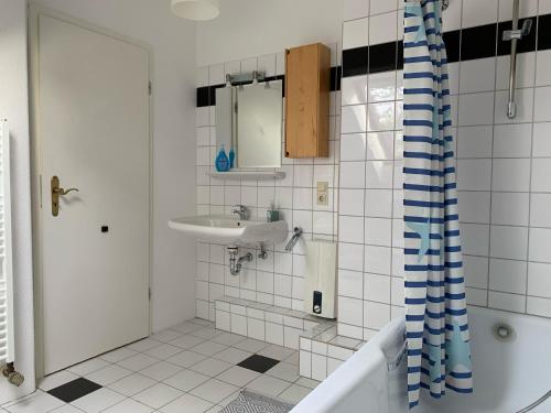 a bathroom with a sink and a tub and a shower at Kleines Apartment in Mönchengladbach-Neuwerk in Mönchengladbach