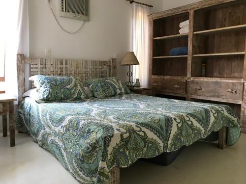 um quarto com uma cama com um cobertor em Villa Oberoi pé na areia alto luxo em Santo André