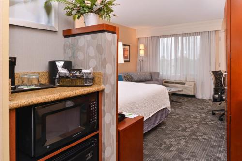 a hotel room with a bed and a kitchen with a microwave at Courtyard by Marriott Boise West/Meridian in Boise