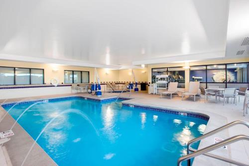 ein Pool mit blauem Wasser in einem Gebäude in der Unterkunft SpringHill Suites by Marriott Omaha East, Council Bluffs, IA in Council Bluffs