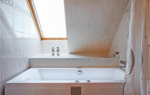 y baño con bañera y ventana. en Pet Friendly Apartment In Nykbing Sj With Wifi, en Højby