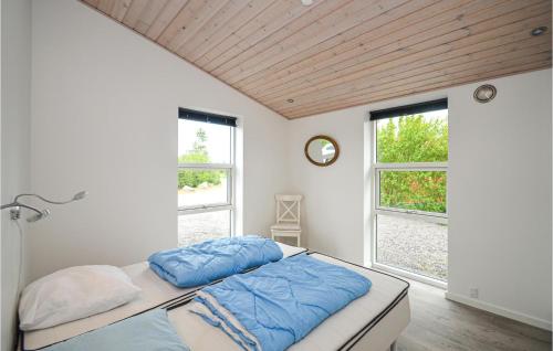 Un dormitorio con una cama con almohadas azules. en 4 Bedroom Beautiful Home In Vggerlse, en Bøtø By