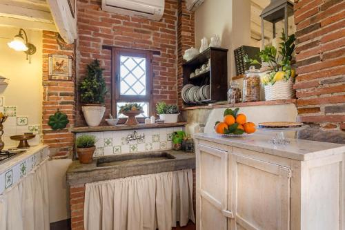 a kitchen with a sink and a brick wall at Rosyabate Cottage, with Private Garden and views between Lucca and Pistoia in Santa Lucia