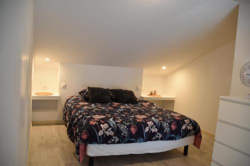a bedroom with a bed with a floral bedspread at Lumineux deux pièces en rez de jardin in Hyères