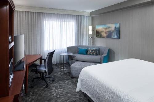 a hotel room with a bed and a chair and a desk at Courtyard Phoenix Chandler/Fashion Center in Chandler