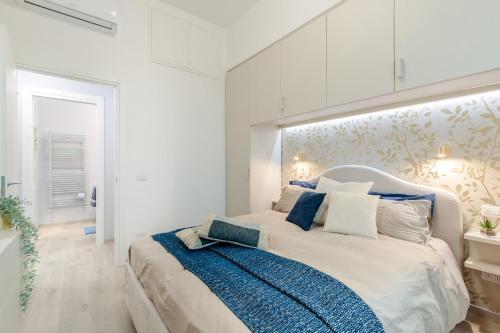 a white bedroom with a large bed with blue accents at Casa Versilia Style in Viareggio