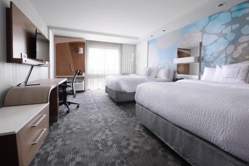 a hotel room with two beds and a desk at Courtyard by Marriott Dallas Plano/The Colony in The Colony