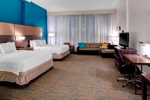 ein Hotelzimmer mit 2 Betten und einem Sofa in der Unterkunft Residence Inn by Marriott Cleveland Downtown in Cleveland