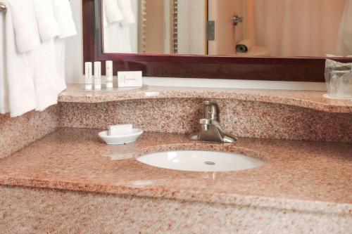 a bathroom counter with a sink and a mirror at SpringHill Suites Houston Pearland in Pearland