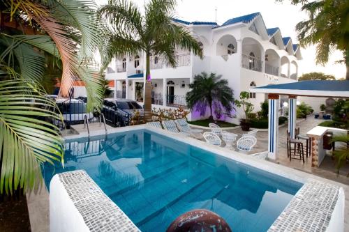 - une piscine en face d'une maison avec un complexe dans l'établissement Hotel Villa Capri, à Boca Chica