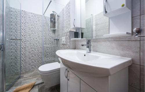 ein weißes Bad mit einem Waschbecken und einem WC in der Unterkunft Amazing Home In Plomin With 3 Bedrooms, Wifi And Outdoor Swimming Pool in Plomin