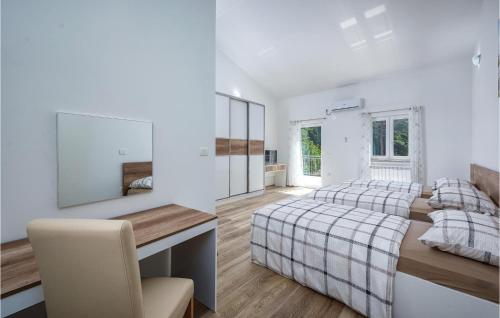ein Schlafzimmer mit einem Bett und einem Schreibtisch mit einem Stuhl in der Unterkunft Amazing Home In Plomin With 3 Bedrooms, Wifi And Outdoor Swimming Pool in Plomin