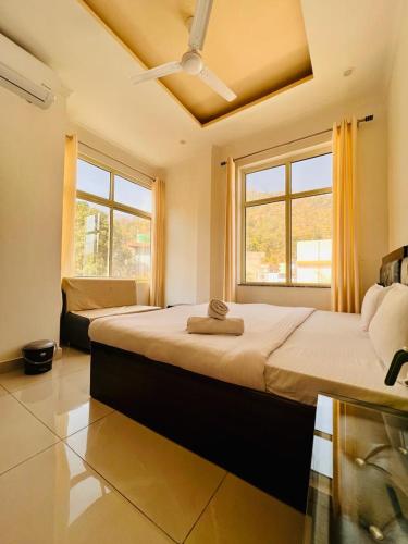 a bedroom with a large bed with a ceiling fan at Hotel Amrit Bliss in Rishīkesh