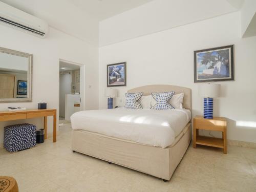 a bedroom with a bed and a desk and a mirror at The Liming Bequia in Friendship
