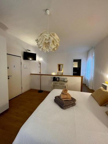 a bedroom with a large white bed and a chandelier at I Limoni di Vernazza in Vernazza