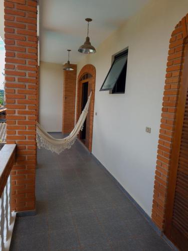 a room with a hammock on the side of a building at Estação Brotense - Casa com piscina e fogueira exclusiva in Brotas