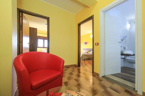 einen roten Stuhl in einem Zimmer mit Bad in der Unterkunft Hotel Miramonti Seulo Turismo Rurale in Seùlo