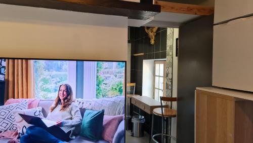 a woman sitting on a couch in a living room at Le Studio de la République in Agde