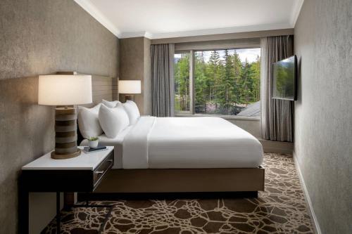 a hotel room with a bed and a window at Kananaskis Mountain Lodge, Autograph Collection in Kananaskis Village