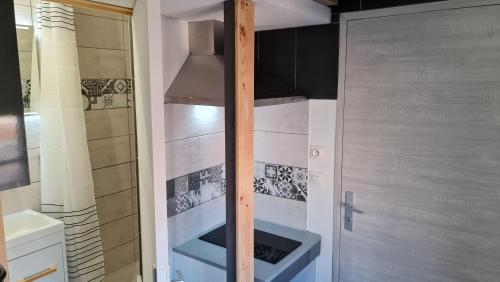 a small bathroom with a sink and a stove at Le Studio de la République in Agde