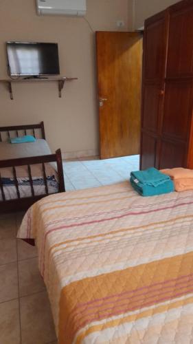 Una habitación de hotel con dos camas y un televisor. en Victoria apart, en San Ramón de la Nueva Orán