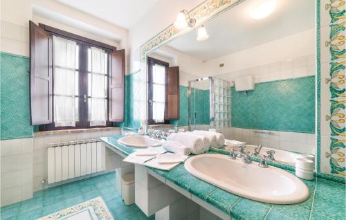 a bathroom with two sinks and a mirror at Stunning Home In Torgiano Pg With Kitchen in Brufa