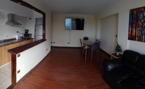 a living room with a couch and a kitchen and a table at Departamento Centro Temuco 3D, 2B, Familiar, Piscina, Estacionamiento in Temuco