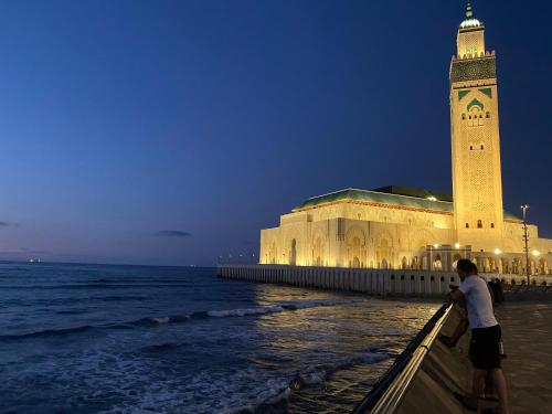 appartement en plein centre de casablanca في الدار البيضاء: مبنى مع برج ساعة بجوار المحيط