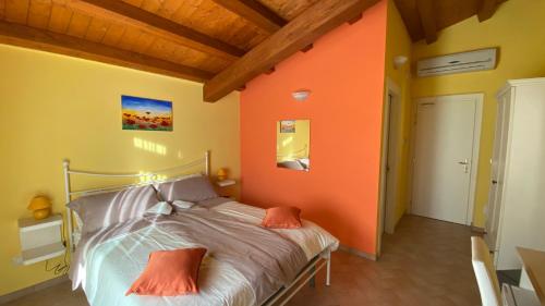 a bedroom with an orange wall and a bed at CasaFè tra sogno e realtà in Narni Scalo