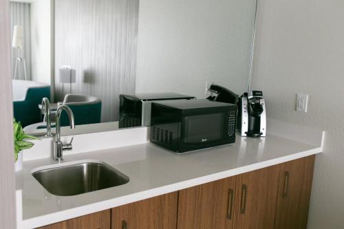 um balcão de cozinha com um lavatório e um micro-ondas em Courtyard Elkhart em Elkhart