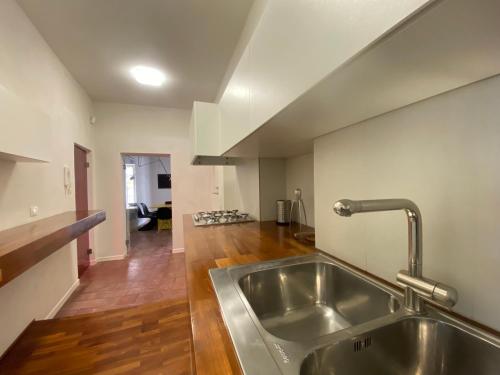 a kitchen with a stainless steel sink and wooden floors at KLEOMENE tempio di Apollo in Siracusa