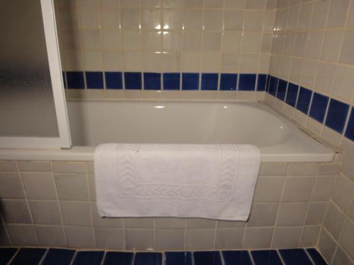 uma banheira branca com uma toalha branca em Le Mas des Gardettes em Saint-Paul-de-Vence