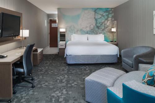 a hotel room with a bed and a desk and chairs at Courtyard by Marriott Vacaville in Vacaville