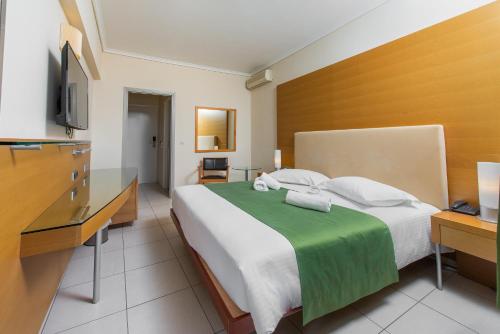 sypialnia z dużym łóżkiem i telewizorem w obiekcie Marmari Bay Hotel w mieście Marmari