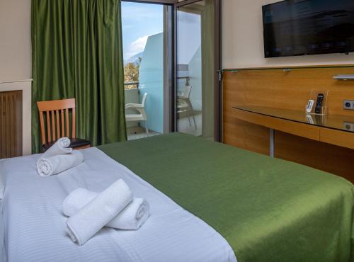 Una habitación de hotel con una cama con toallas. en Marmari Bay Hotel en Marmarion